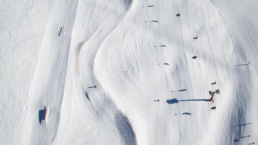 The people are skiing down the slope below