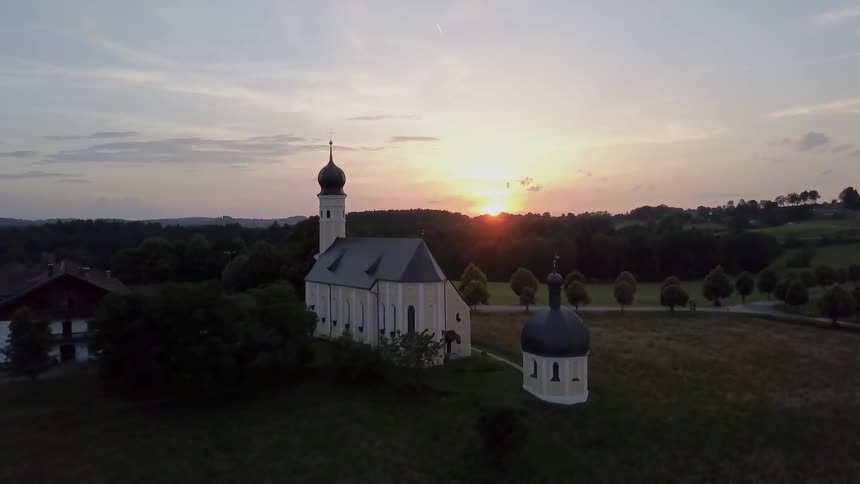 Aerial view of church on a field at sunset