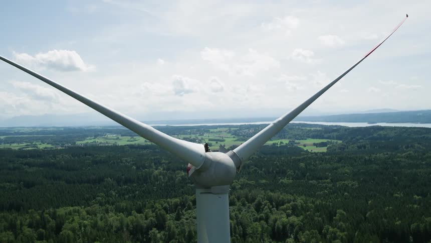 White turbine blades are still and stand tall over the landscape