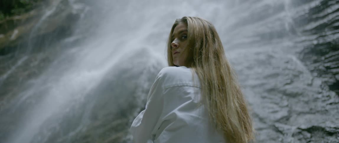 A female posing under the waterfall