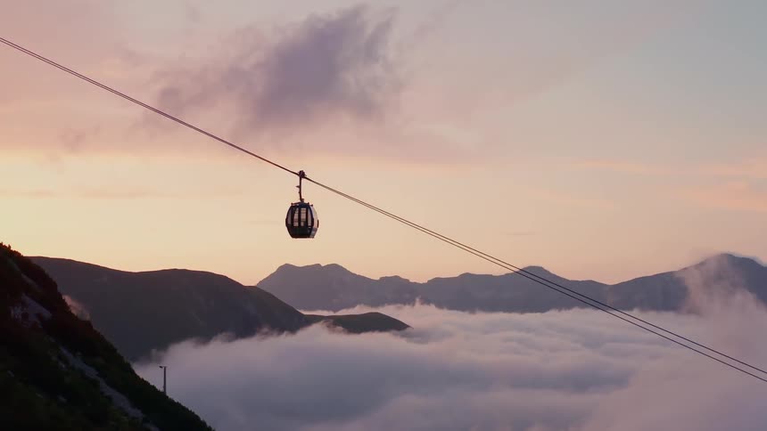 Gondolas moving above the clouds