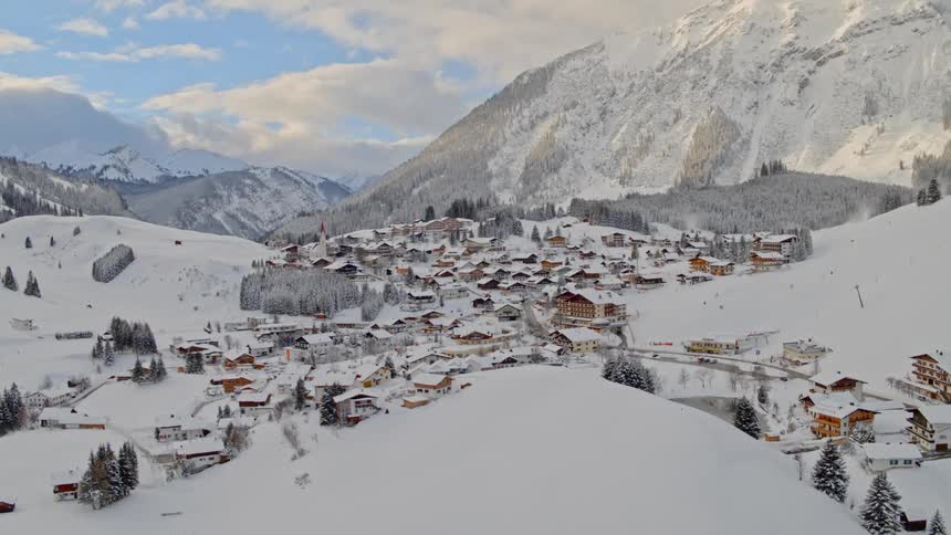 A mountain side resort is covered with snow