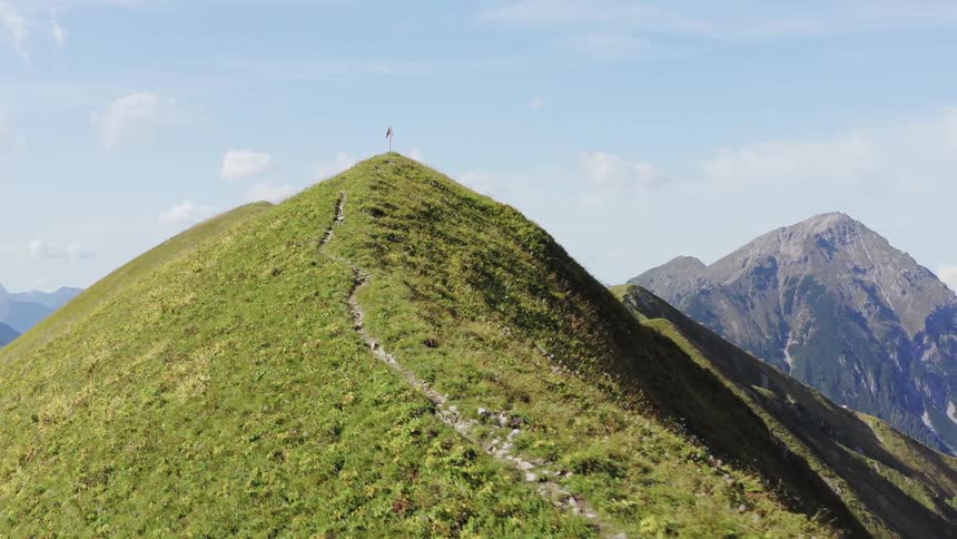 A triangle shaped sign sits at the top of a mountain peak