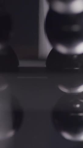 Balls knock into each other and reflect off of a glossy surface