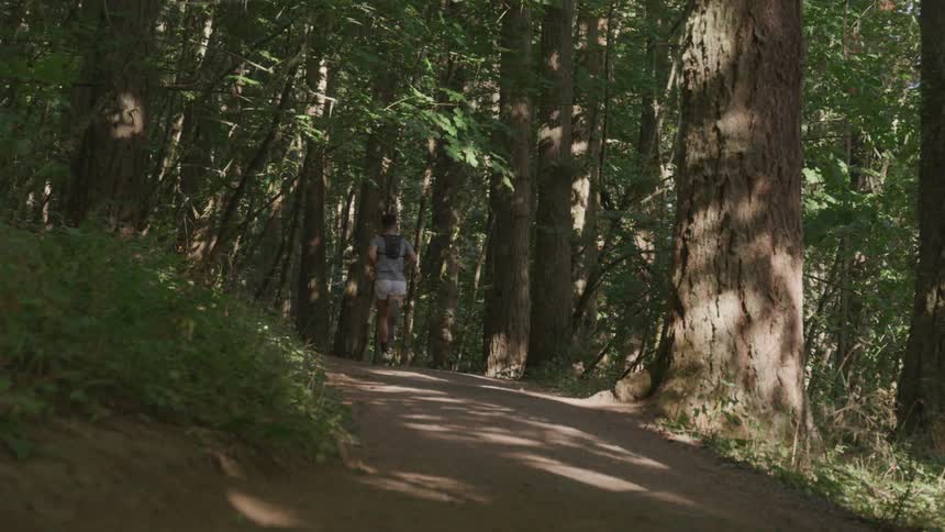 A young man runs along a dirt path