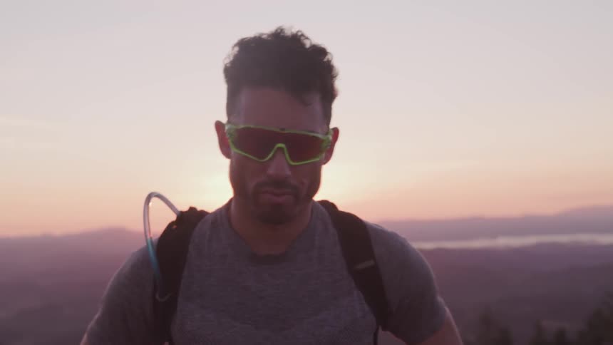 Man walks forward as sun rises over mountain range