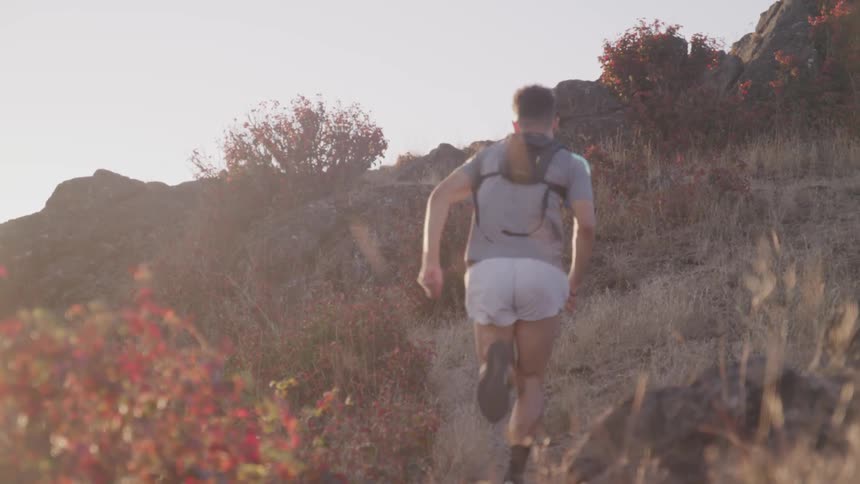 Man runs uphill at sunset