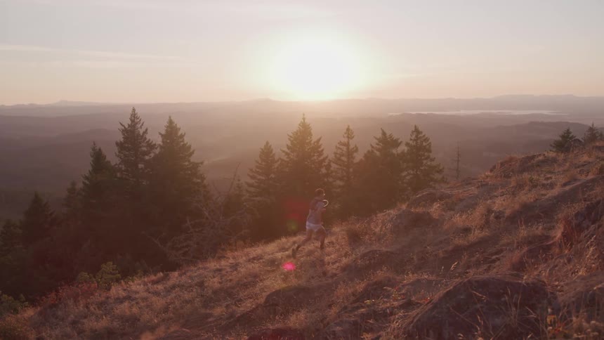 Man runs uphill at sunset
