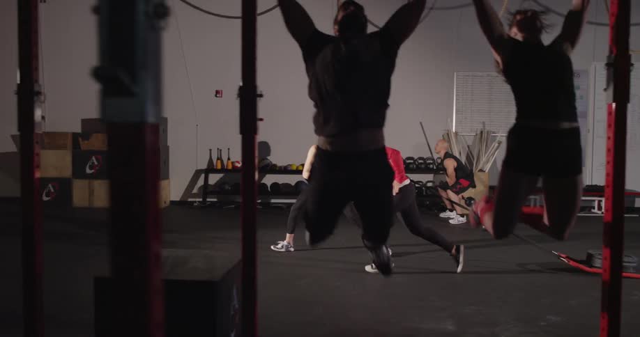 A personal trainer encourages another woman at the gym