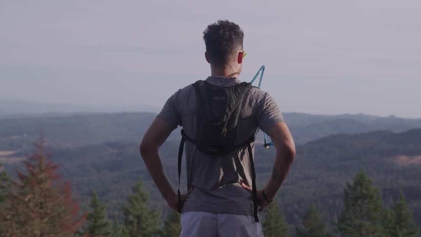 Man stands on the top of mountain and looks at the view