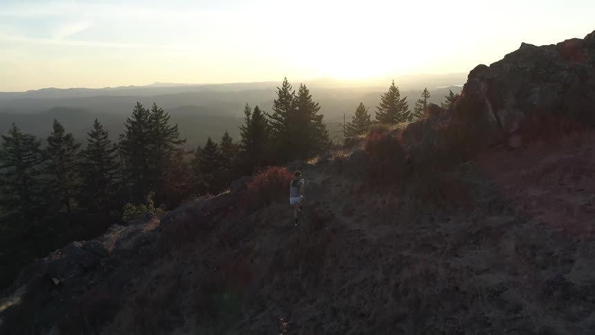 A man running on the hill at dawn
