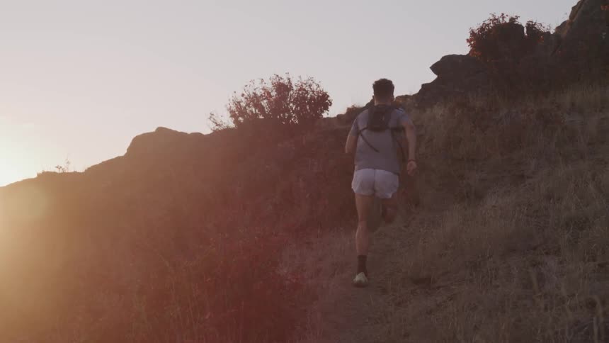 Man runs uphill at sunset