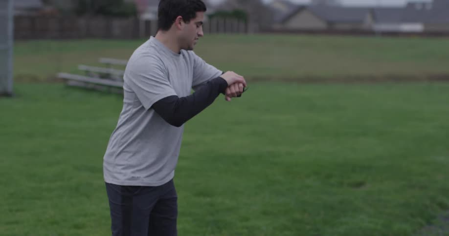 A man is timing a runner on a cloudy day