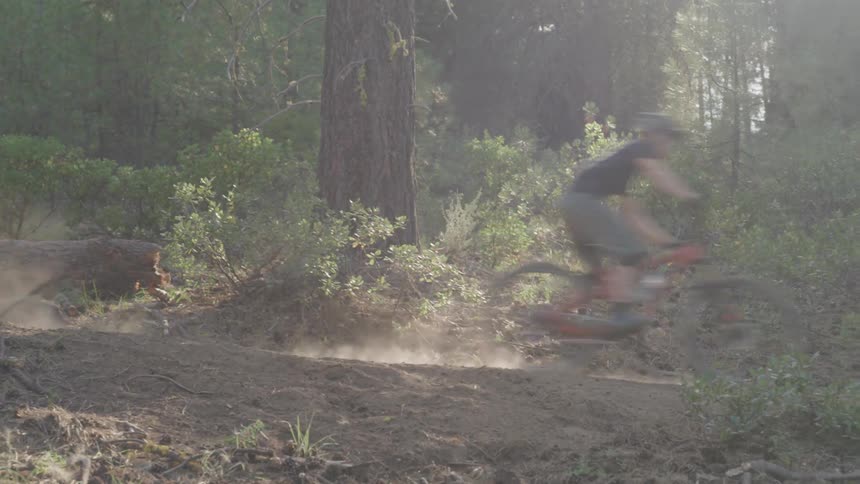 A person races downhill on his mountain bike