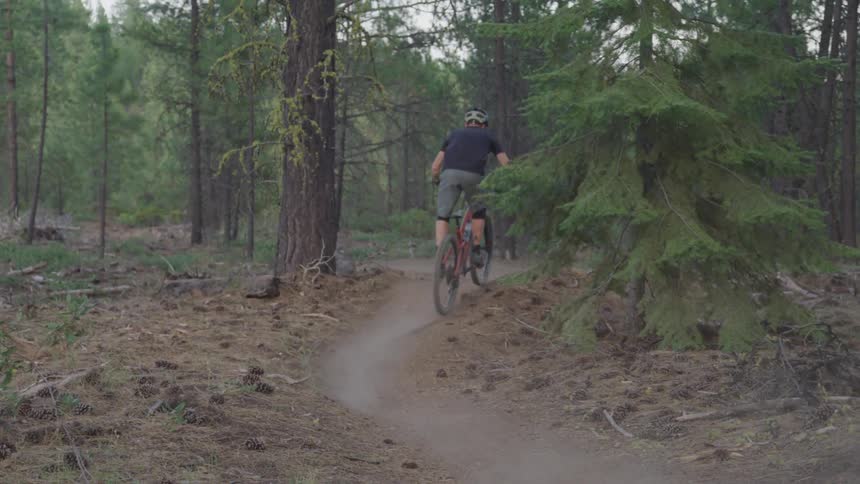 A man rides a mountain bike through a park path