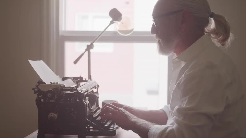 A man is typing on an old typewriter