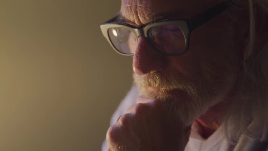 An old man thinking under the light