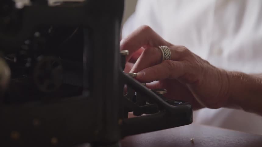 Older person types on old manual typewriter