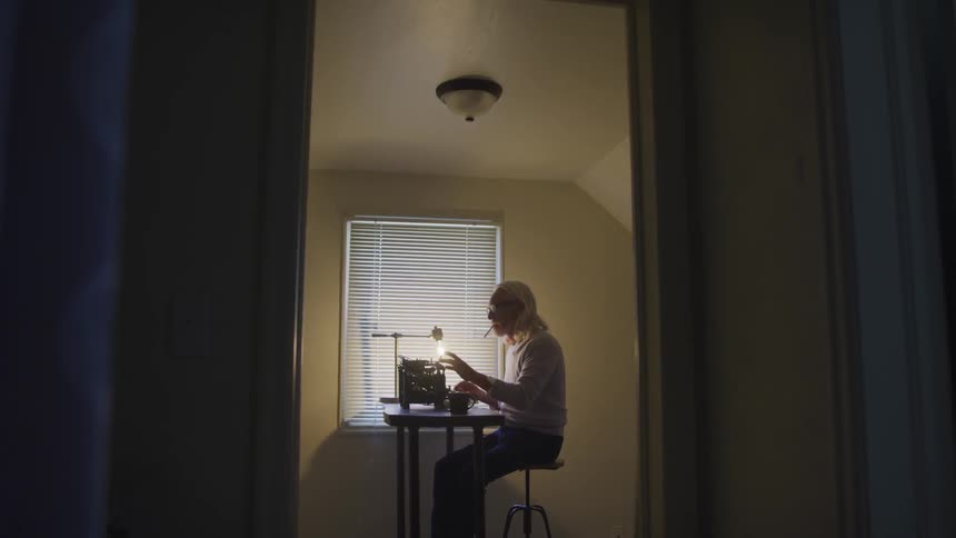 An old man typing in the room