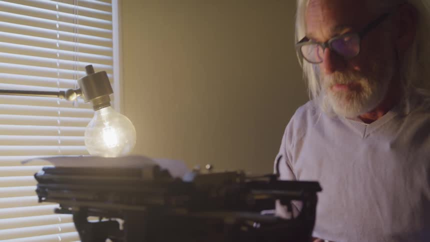 White man typing on a typewriter