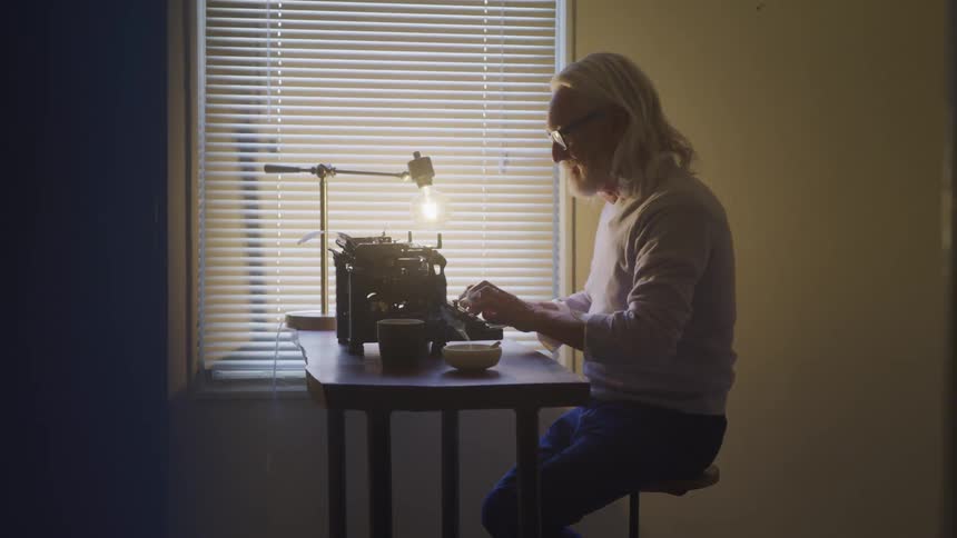 An old man typing on the typing machine