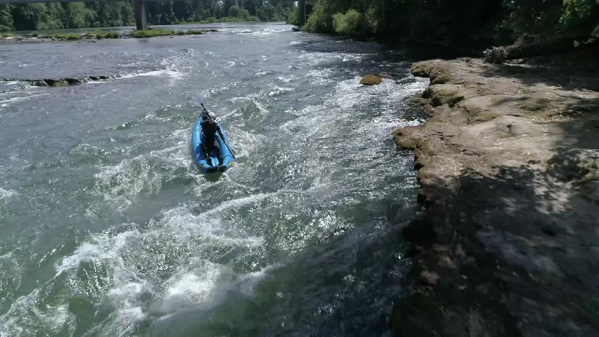 A person kayaks in rough water
