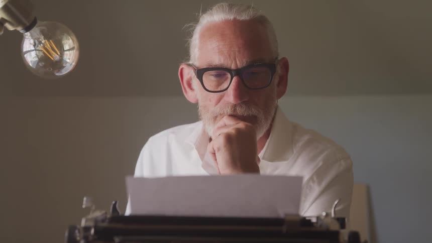 A man works at an antique typewriter