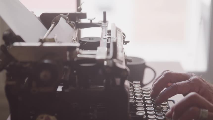 A hand typing at the old type machine