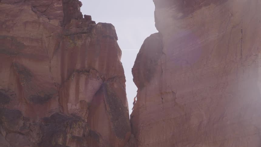 Person climbs up the side of the mountain