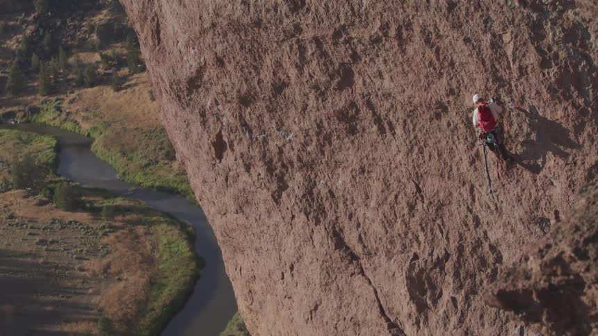 A man doing a rock climbing on a cliff