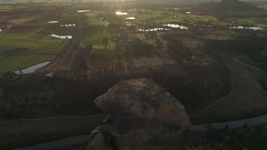 An aerial view of a big rock near a small city