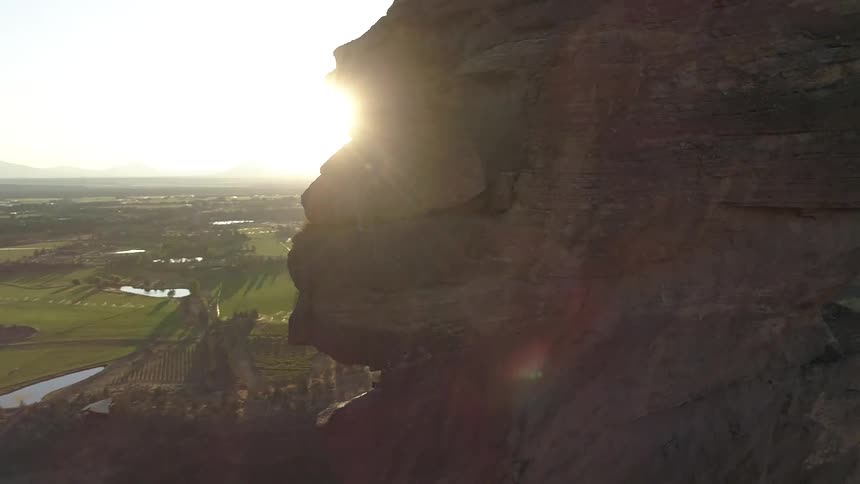 Rock climbers climb up a rock face high above a valley