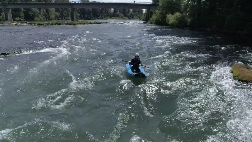 A man kayaks in rough water