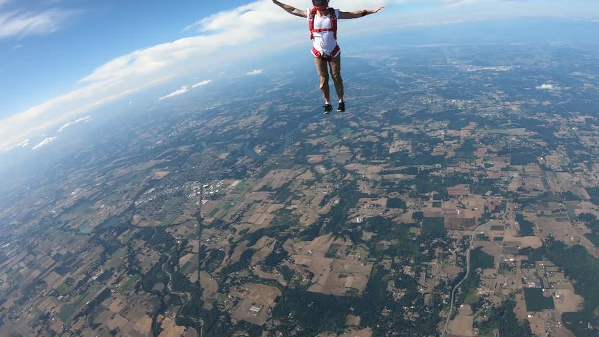 A person holds on to another and then lets go to free fall from an aircraft