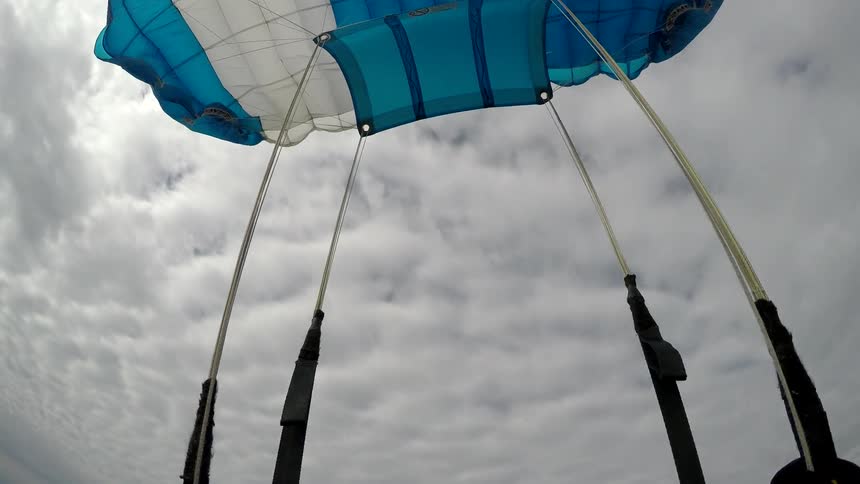 Sky diver using parachute on cloudy day