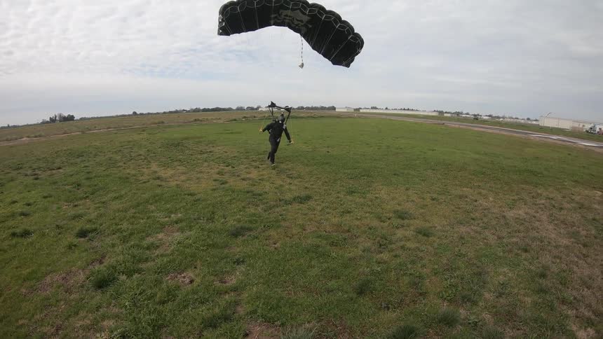 A man runs as his parachute lands