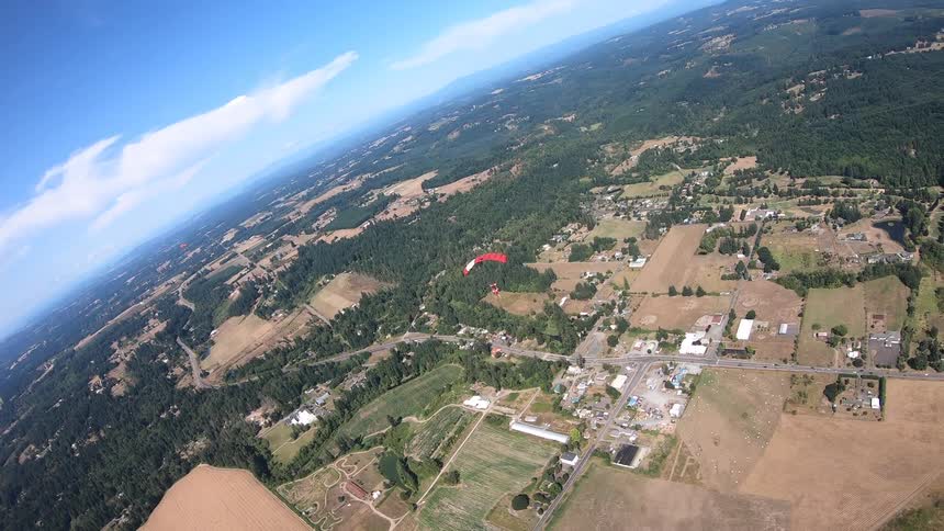 A skydiver glides down towards the ground