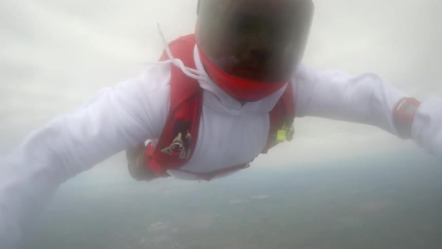 People grabbing hands and flipping mid air while skydiving