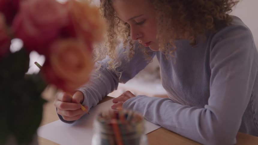 A curly blonde hair woman writing at the paper