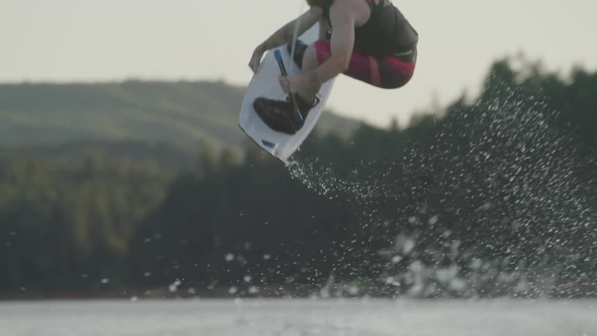Man jumps while wakeboarding in lake during day