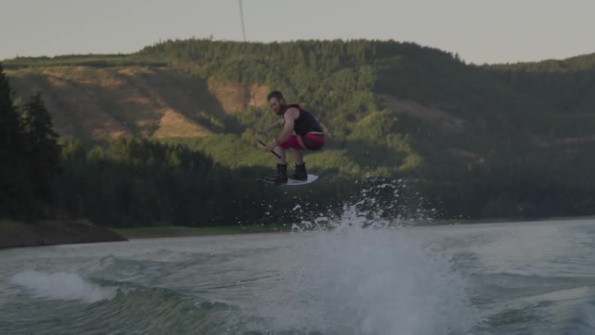 A man water skiing over waves