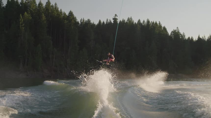 Wake surfer performs jump over boat wake