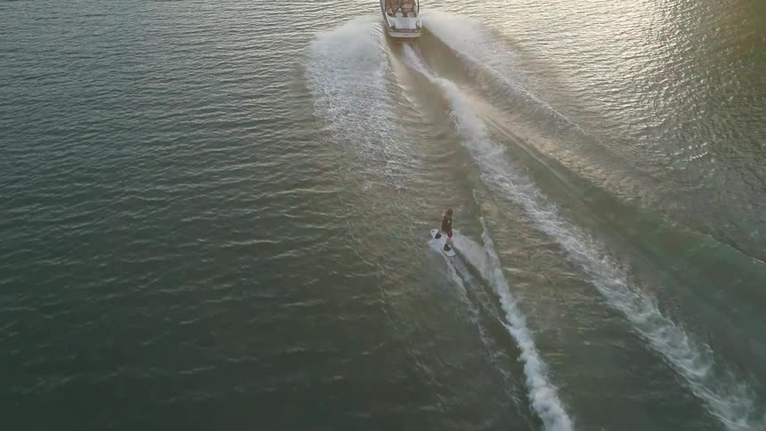 Motorboat pulls someone standing on a wake board