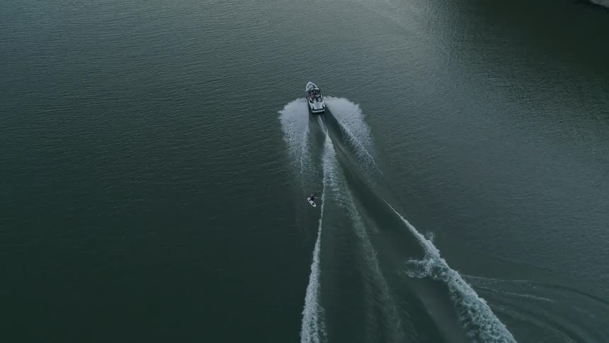Man wakeboarding behind a boat