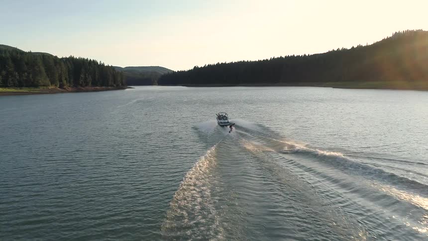 A person is water skiing behind a boat
