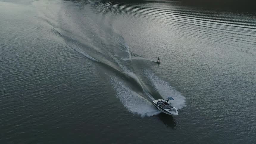 A boat pulls a water skier across a lake