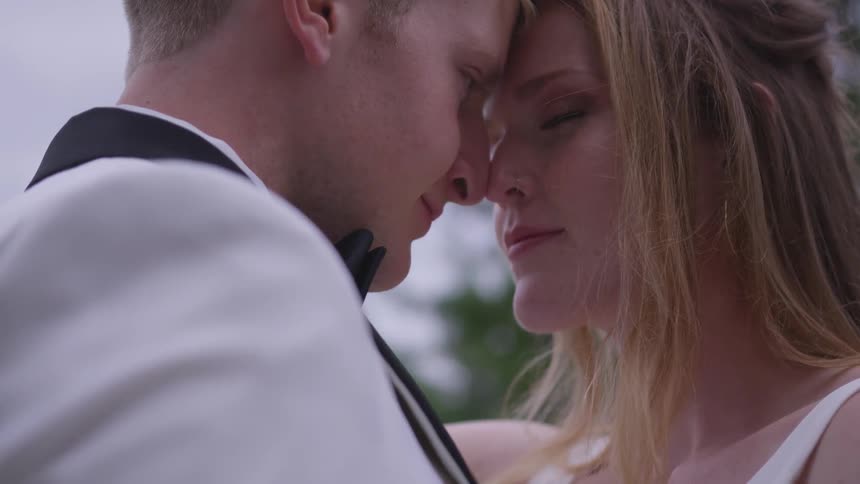 Groom and bride hold each other during the wedding ceremony