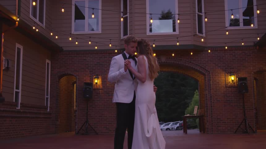 A bride and groom dance together in a courtyard