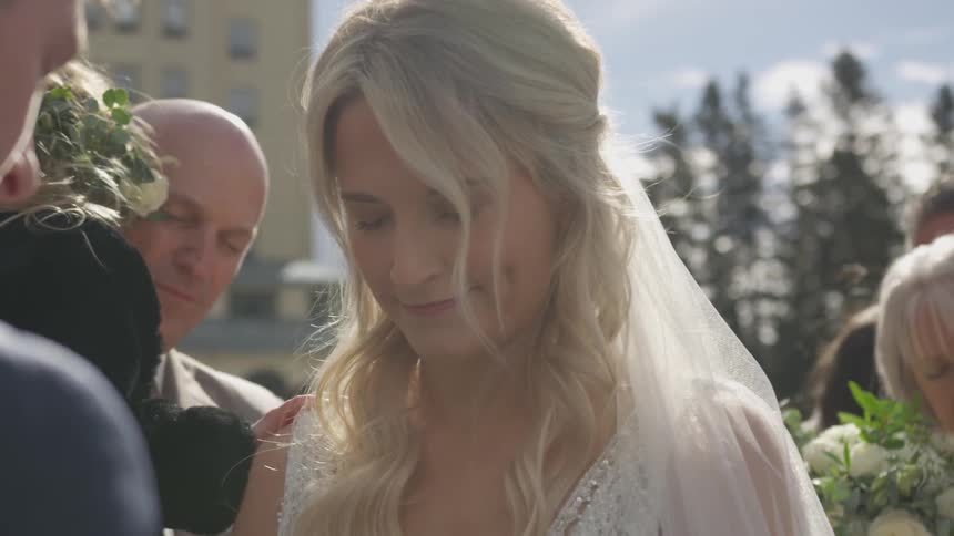A bride hangs her head in prayer standing at the alter