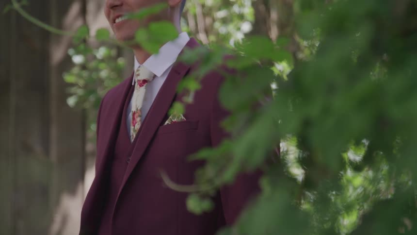 A man is standing outside while wearing a tuxedo